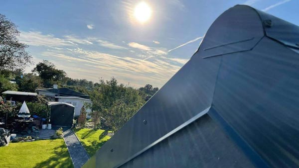 Nahaufname eines Dachgiebels mit Blick auf einen Garten